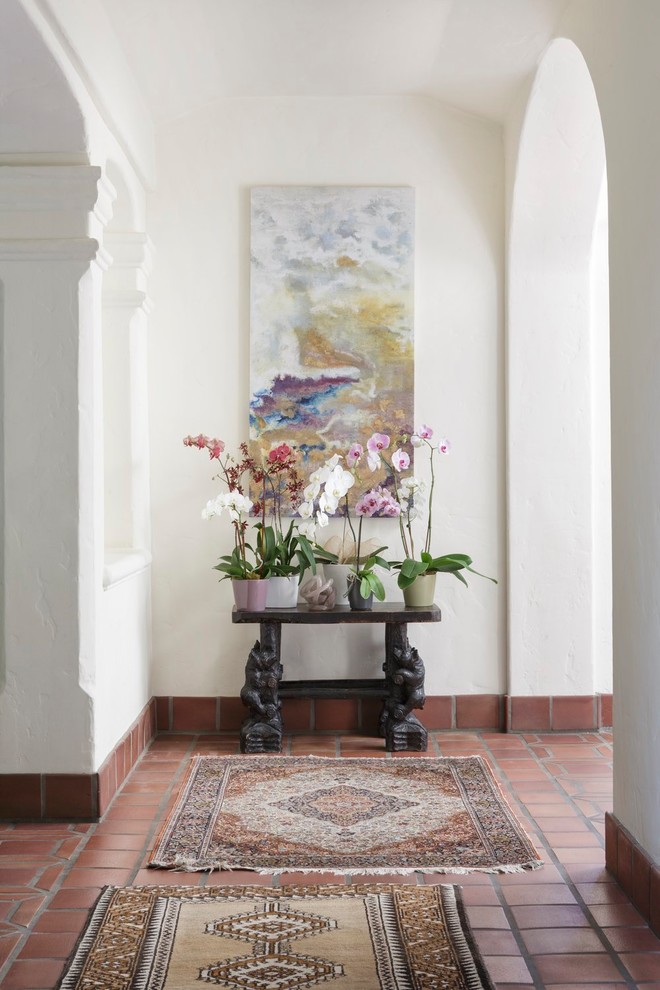 Hallway - mid-sized mediterranean terra-cotta tile and brown floor hallway idea in San Francisco with white walls