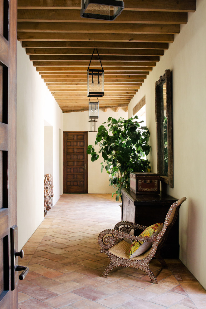 Пример оригинального дизайна: коридор в средиземноморском стиле с белыми стенами, полом из терракотовой плитки и розовым полом