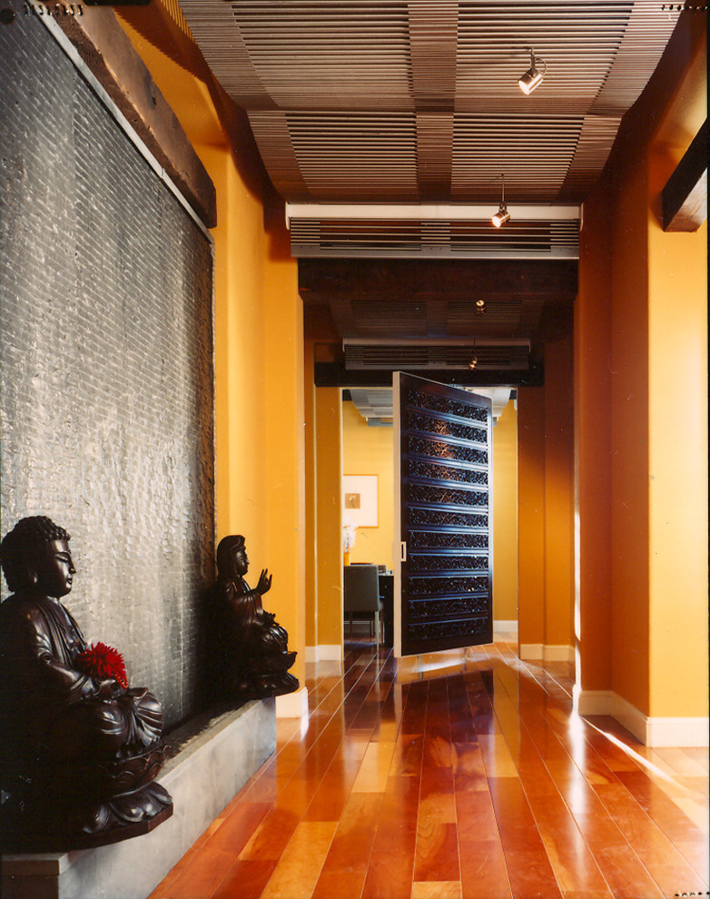 Cette image montre un couloir asiatique avec un mur orange, un sol en bois brun et un sol orange.