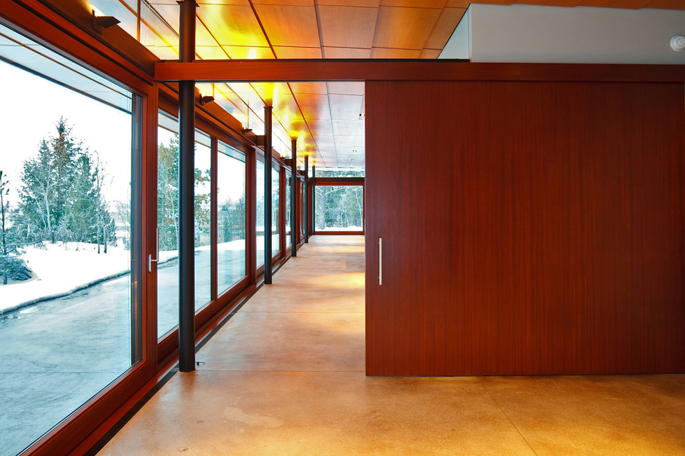 Стильный дизайн: большой коридор в современном стиле с бетонным полом и коричневым полом - последний тренд