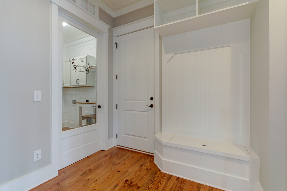 Example of a mid-sized country medium tone wood floor and brown floor hallway design in Raleigh with gray walls