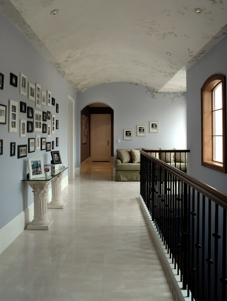 Exempel på en stor klassisk hall, med blå väggar och kalkstensgolv