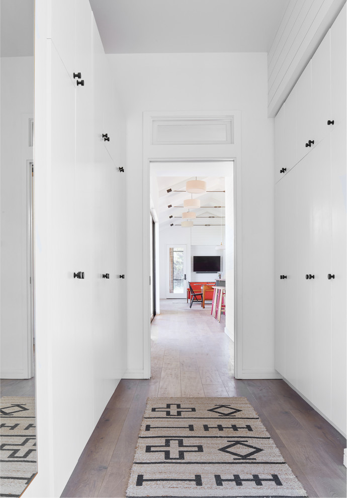 Esempio di un ingresso o corridoio scandinavo con pareti bianche, pavimento in legno massello medio e pavimento marrone