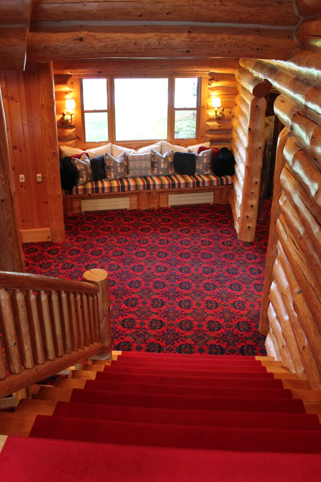 Rustik inredning av en stor hall, med bruna väggar, heltäckningsmatta och rött golv
