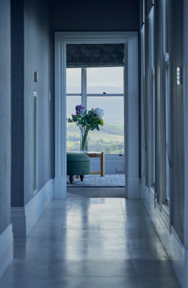 На фото: огромный коридор в классическом стиле с синими стенами, ковровым покрытием и синим полом с
