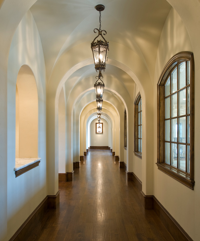 Elegant dark wood floor hallway photo in Dallas with white walls