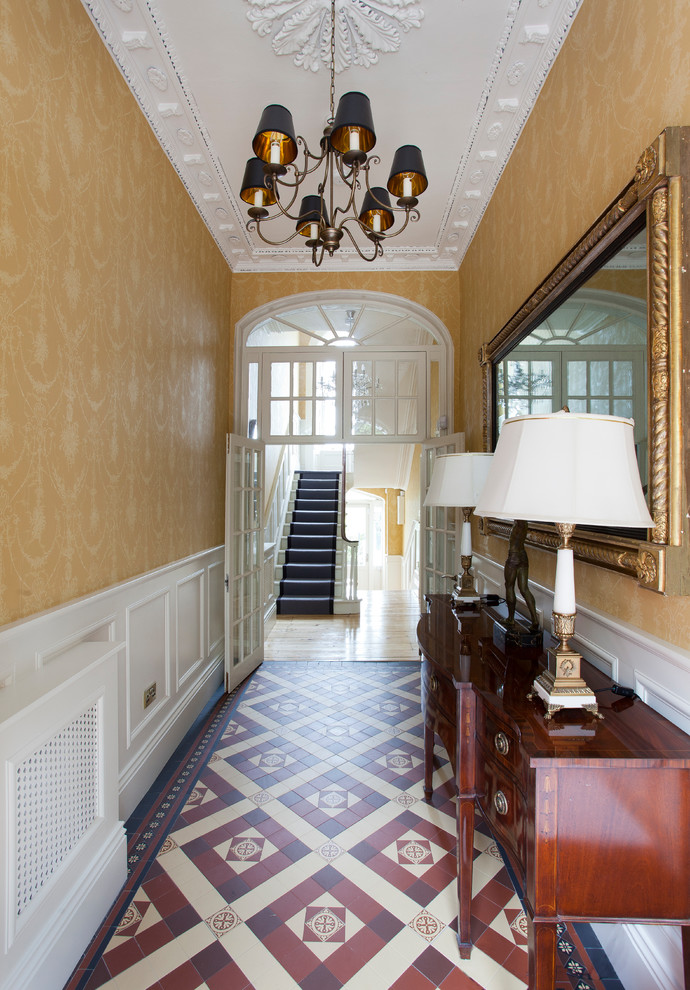 Стильный дизайн: коридор среднего размера в классическом стиле с желтыми стенами, полом из линолеума и разноцветным полом - последний тренд