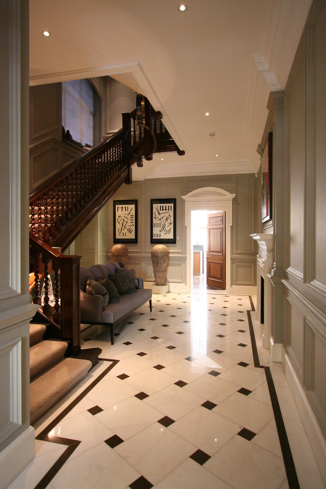 Aménagement d'un grand couloir classique avec un mur gris et un sol en marbre.
