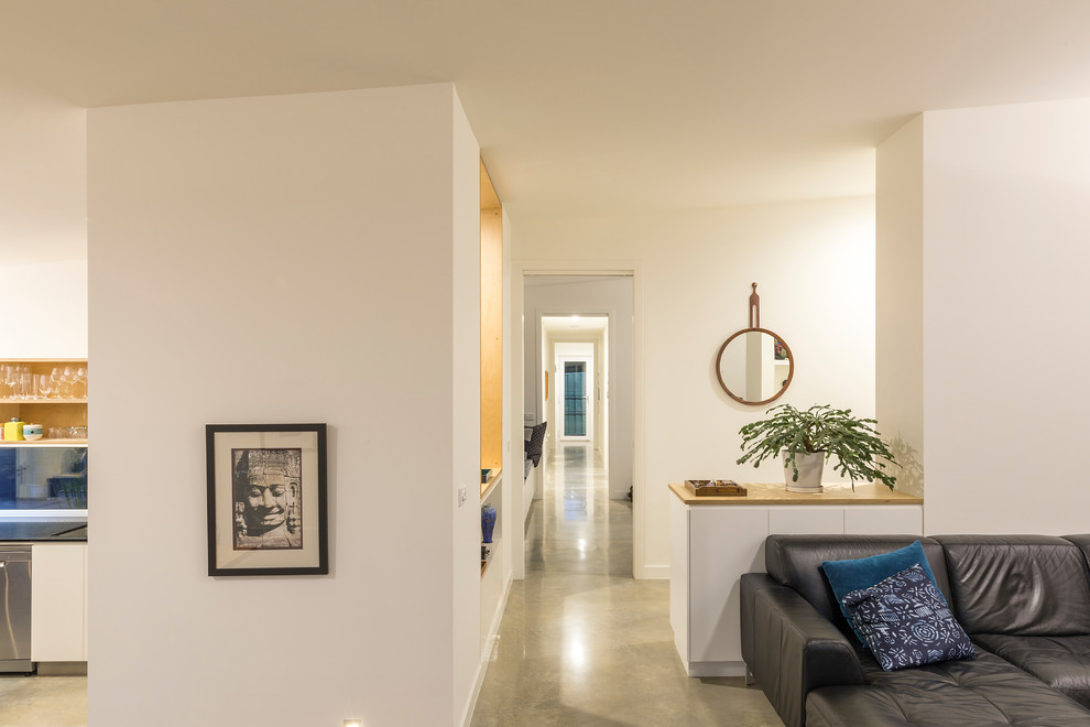 На фото: коридор среднего размера в современном стиле с белыми стенами, бетонным полом и серым полом с