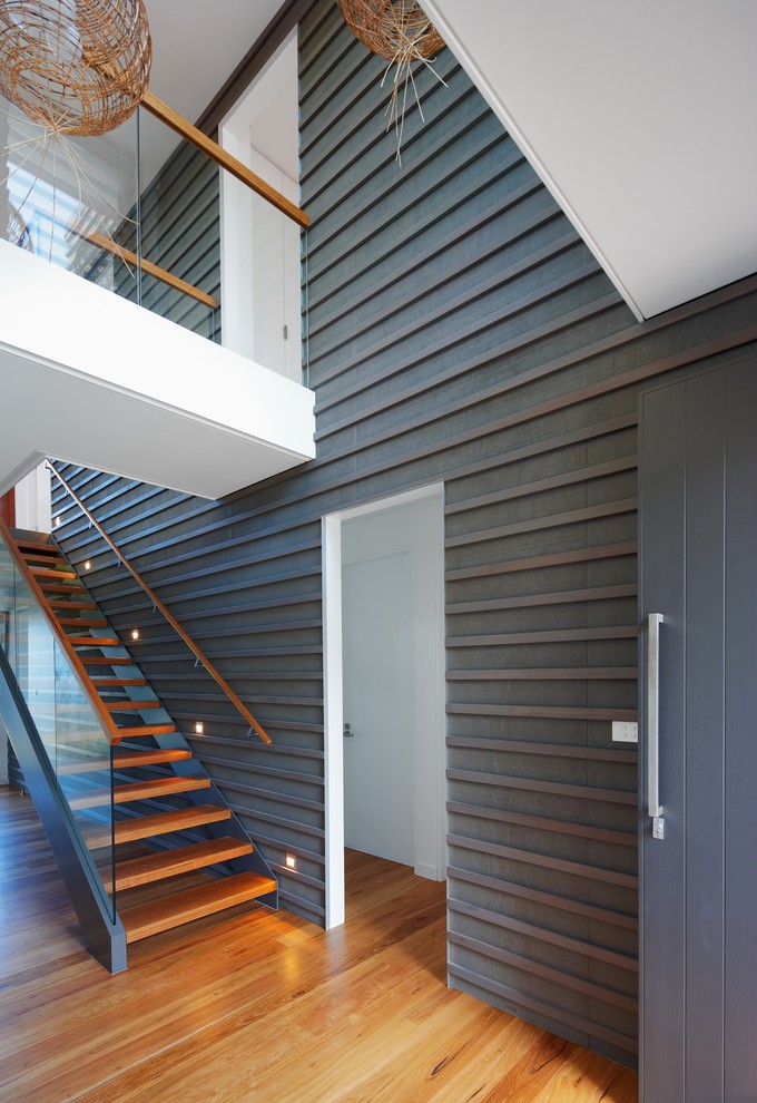 Cette photo montre un couloir tendance avec un mur gris et un sol en bois brun.