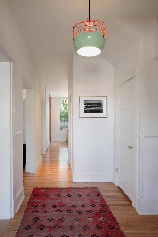 Aménagement d'un couloir classique de taille moyenne avec un mur blanc, parquet clair et un sol marron.