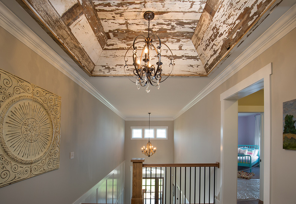 Example of a large farmhouse medium tone wood floor hallway design in Columbus with beige walls
