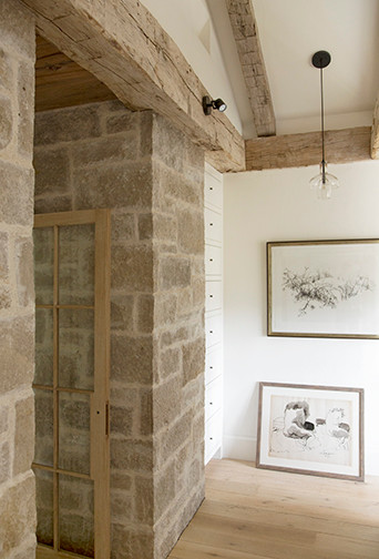 Inredning av en lantlig liten hall, med vita väggar, ljust trägolv och beiget golv