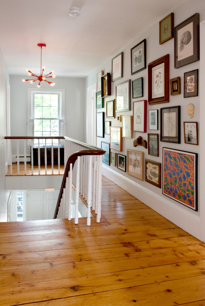 Transitional medium tone wood floor hallway photo in Boston with white walls