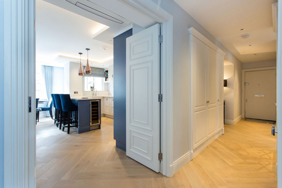 Idee per un ingresso o corridoio minimal di medie dimensioni con pareti blu, parquet chiaro e pavimento beige