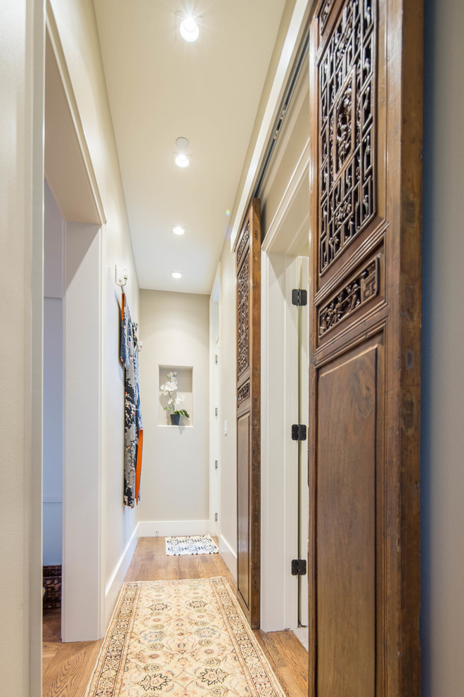 Hallway - mid-sized eclectic light wood floor hallway idea in Austin with beige walls