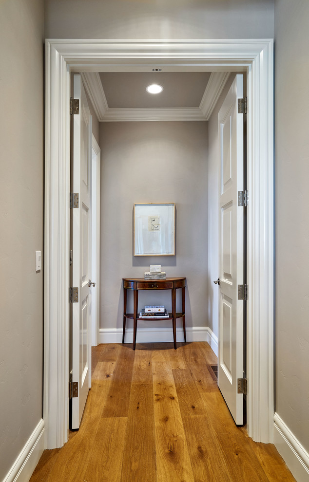 Exemple d'un couloir chic de taille moyenne avec un mur gris et parquet clair.