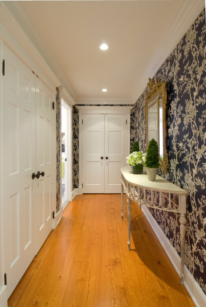 Ispirazione per un ingresso o corridoio tradizionale di medie dimensioni con pareti bianche, pavimento in legno massello medio e pavimento marrone