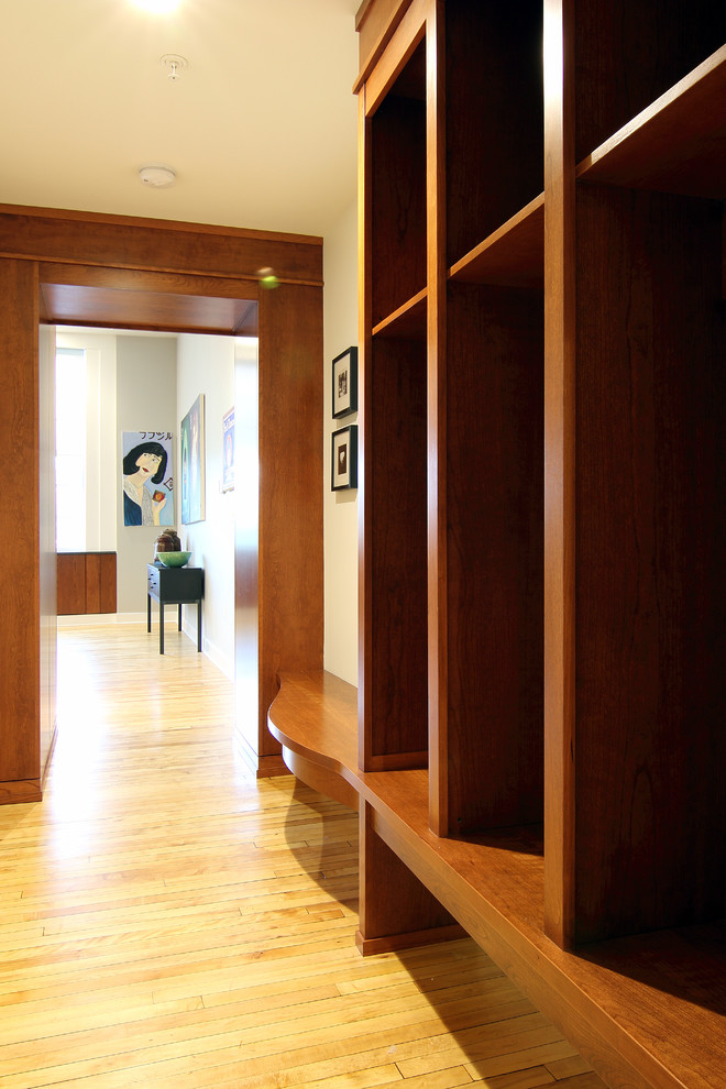 Réalisation d'un couloir minimaliste de taille moyenne avec un mur beige et un sol en bois brun.