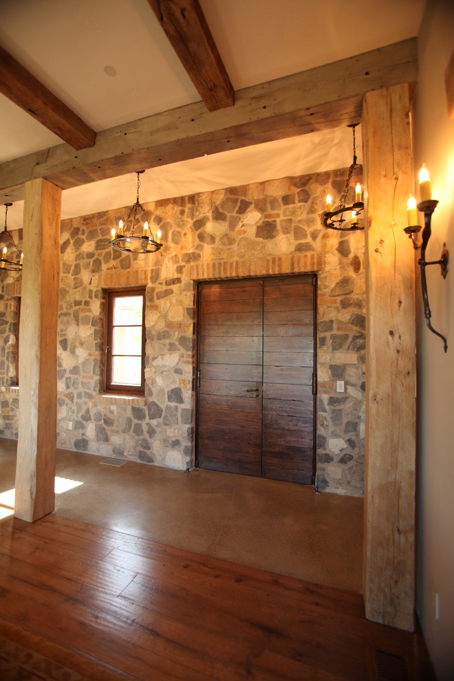 Modelo de recibidores y pasillos rústicos grandes con paredes grises y suelo de madera en tonos medios