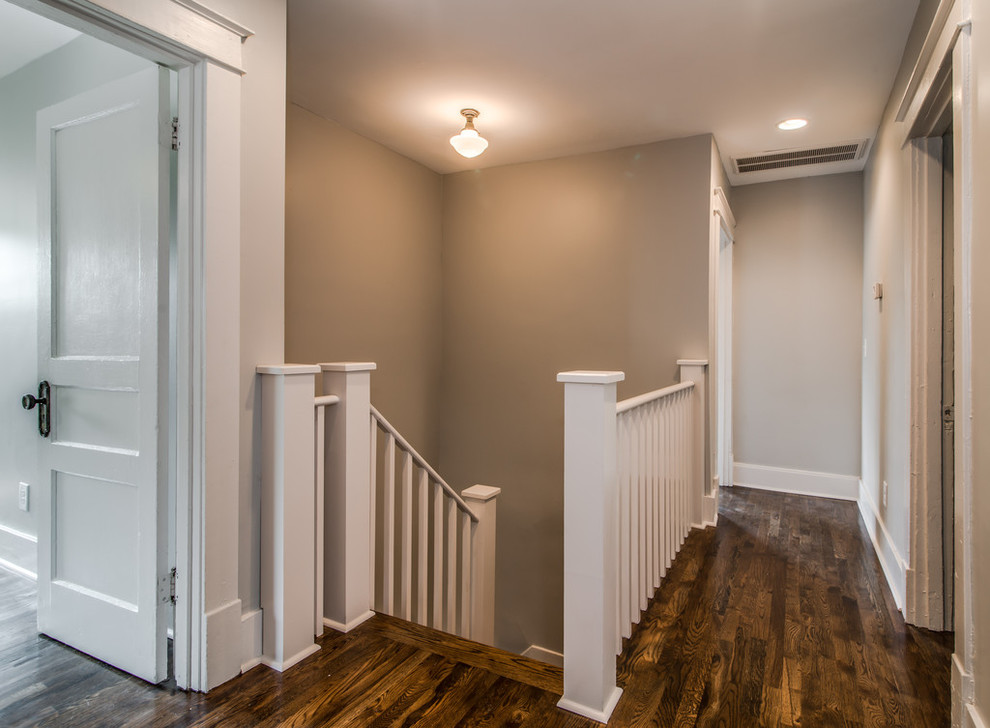 Cette image montre un petit couloir traditionnel avec un mur gris et un sol en bois brun.