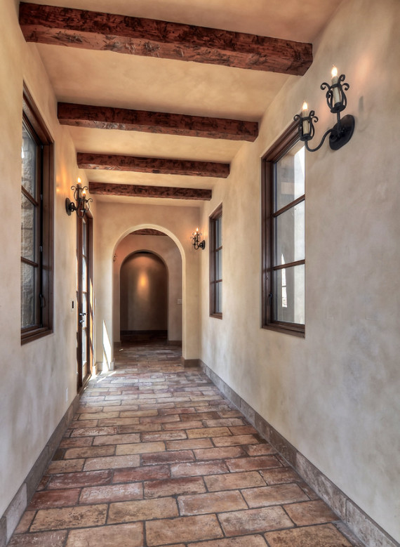 Inspiration for a mid-sized mediterranean brick floor and beige floor hallway remodel in Los Angeles with beige walls