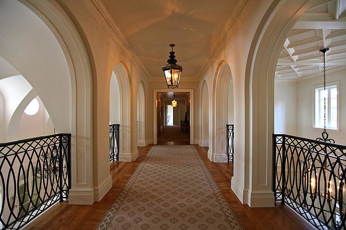 Immagine di un grande ingresso o corridoio mediterraneo con pareti beige e pavimento in legno massello medio