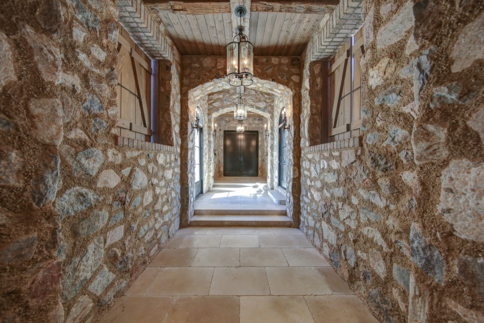 Ejemplo de recibidores y pasillos mediterráneos grandes con paredes marrones y suelo beige