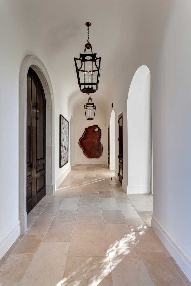 Пример оригинального дизайна: огромный коридор в средиземноморском стиле с белыми стенами и полом из известняка