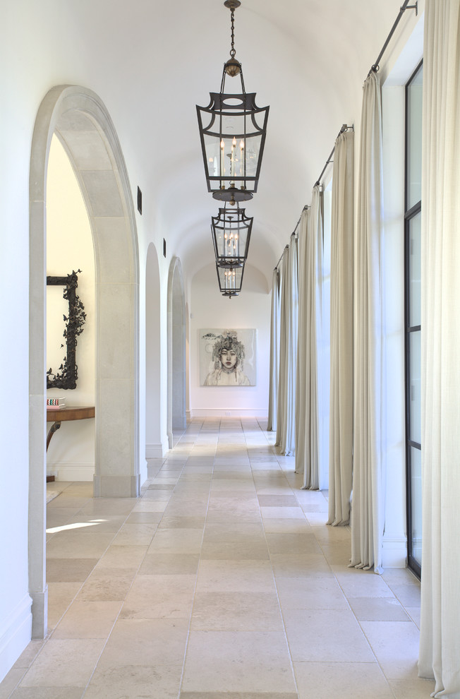 Esempio di un grande ingresso o corridoio mediterraneo con pareti bianche, pavimento grigio e pavimento in pietra calcarea