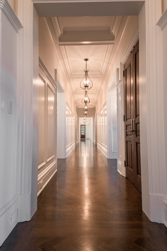 Hallway - huge traditional dark wood floor hallway idea in New York with white walls