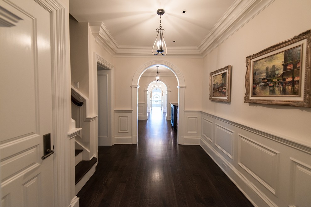 Идея дизайна: огромный коридор в классическом стиле с белыми стенами и темным паркетным полом