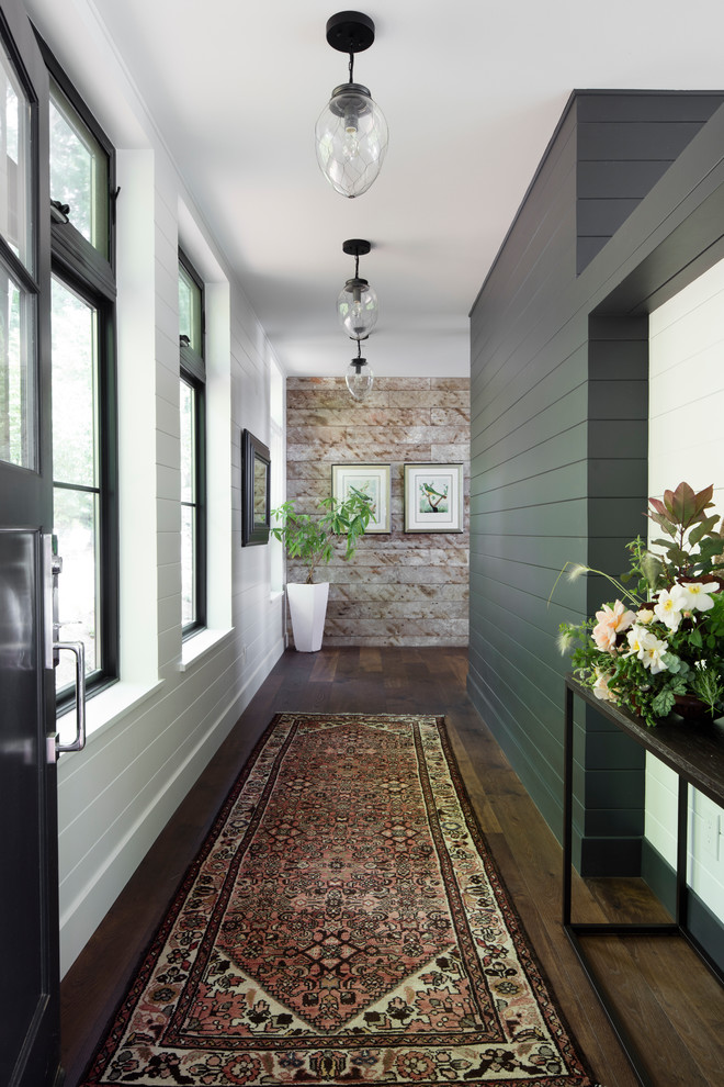 Example of a large farmhouse dark wood floor and brown floor hallway design in Seattle with white walls