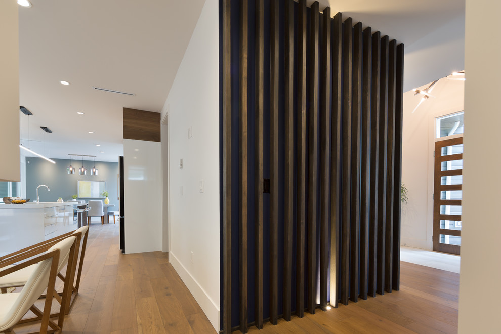 Ispirazione per un ingresso o corridoio moderno di medie dimensioni con pareti bianche e pavimento in legno massello medio