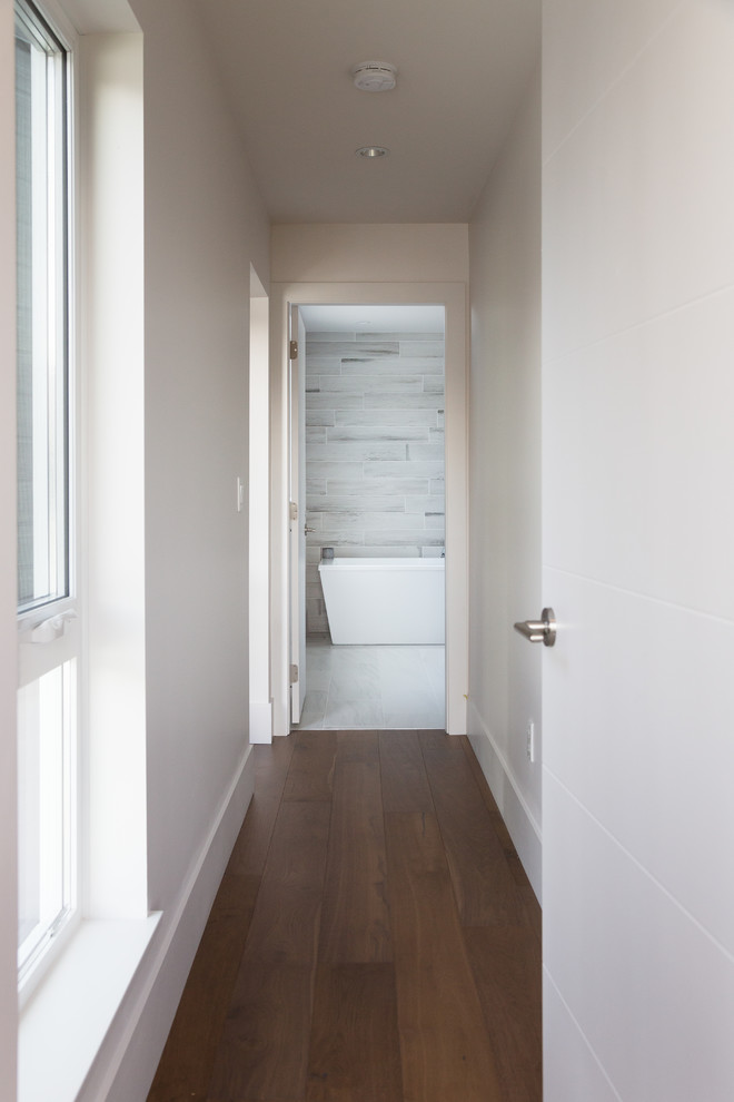 На фото: коридор среднего размера в стиле модернизм с белыми стенами и паркетным полом среднего тона