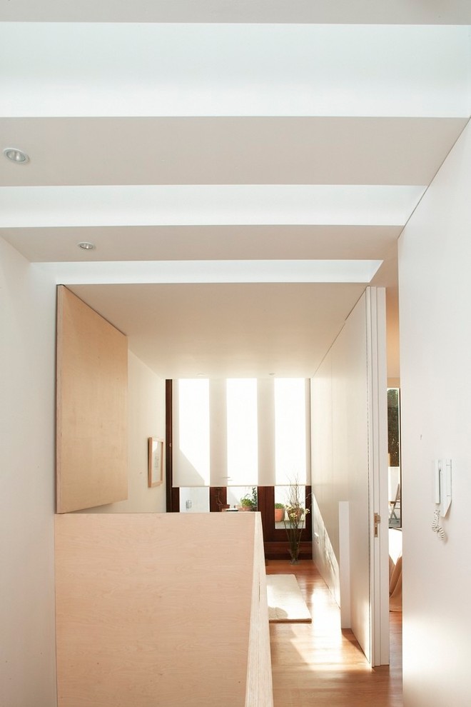 Hallway - mid-sized contemporary medium tone wood floor and brown floor hallway idea in Dublin with white walls