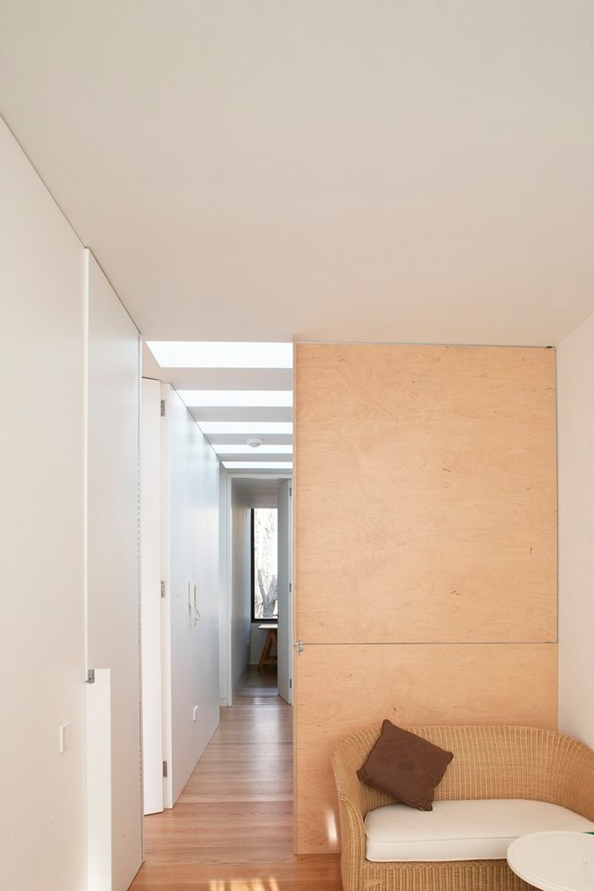 Idee per un ingresso o corridoio contemporaneo di medie dimensioni con pareti bianche, pavimento in legno massello medio e pavimento marrone