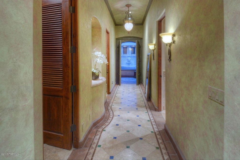 Foto på en mellanstor medelhavsstil hall, med flerfärgade väggar och travertin golv