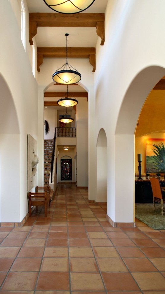 フェニックスにある広いサンタフェスタイルのおしゃれな廊下 (白い壁、テラコッタタイルの床) の写真