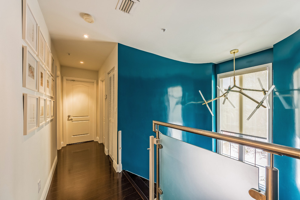 На фото: коридор среднего размера в стиле фьюжн с синими стенами и темным паркетным полом с
