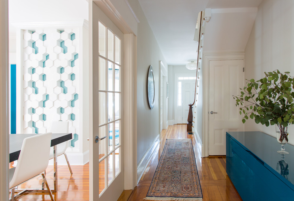 Mittelgroßer Moderner Flur mit weißer Wandfarbe und braunem Holzboden in Boston