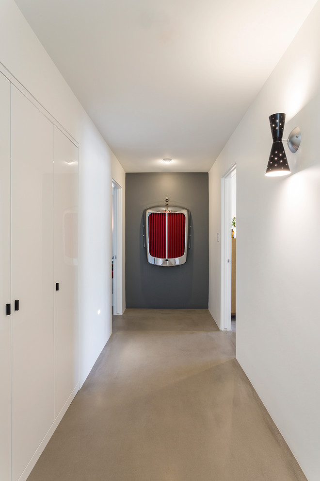 На фото: коридор в стиле ретро с серыми стенами, бетонным полом и серым полом