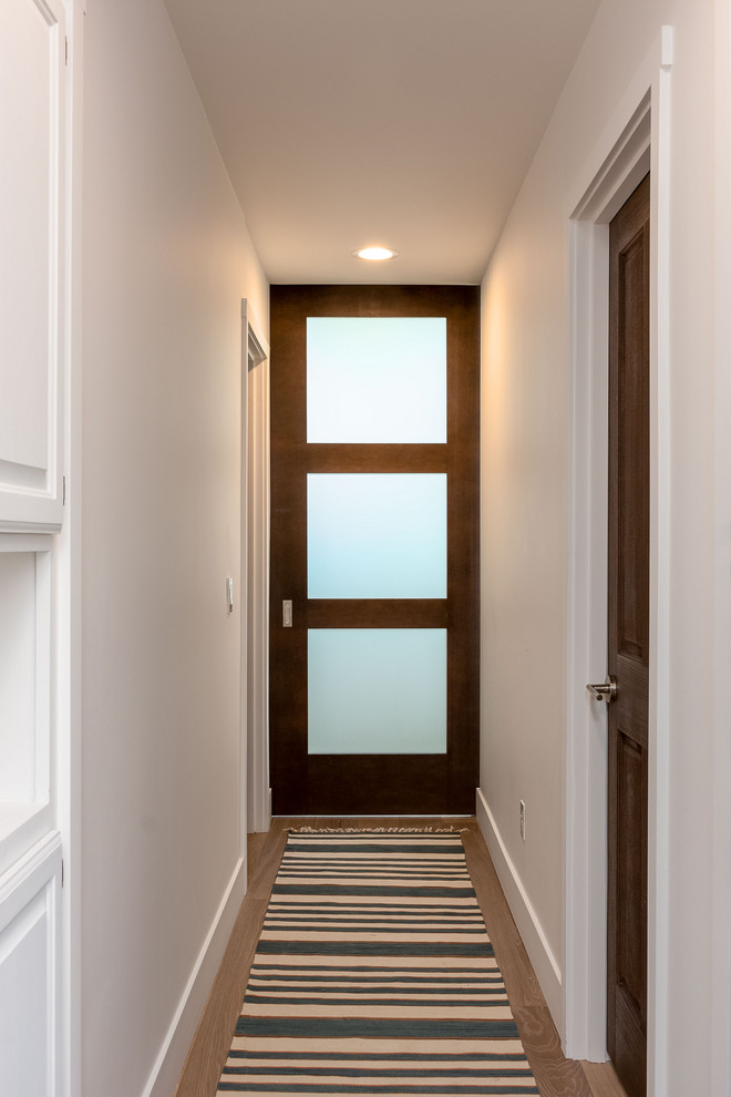 На фото: огромный коридор в стиле ретро с белыми стенами, светлым паркетным полом и коричневым полом