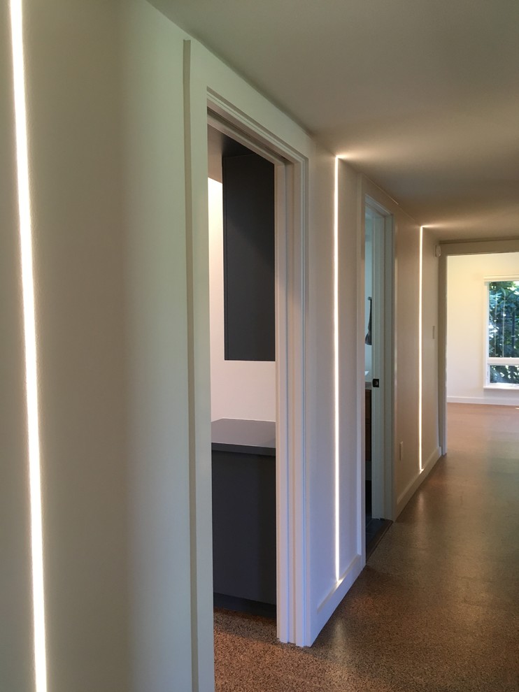На фото: коридор в стиле фьюжн с белыми стенами, пробковым полом и коричневым полом