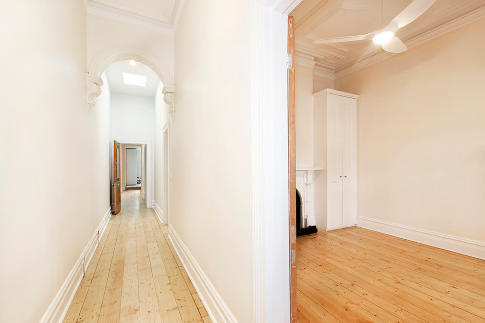 Idéer för en liten modern hall, med vita väggar, ljust trägolv och beiget golv