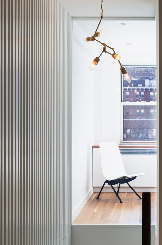 Ispirazione per un ingresso o corridoio minimalista di medie dimensioni con pareti bianche, pavimento in legno massello medio e pavimento marrone