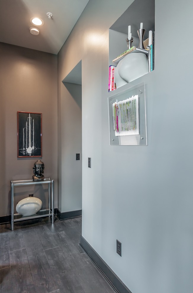 Idée de décoration pour un petit couloir design avec un mur gris et parquet foncé.