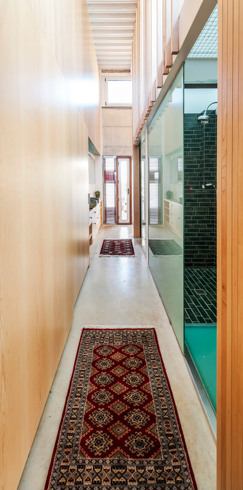 Ispirazione per un piccolo ingresso o corridoio minimal con pareti marroni e pavimento in cemento