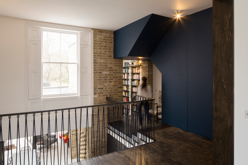 Mittelgroßer Moderner Flur mit blauer Wandfarbe, Sperrholzboden und braunem Boden in London