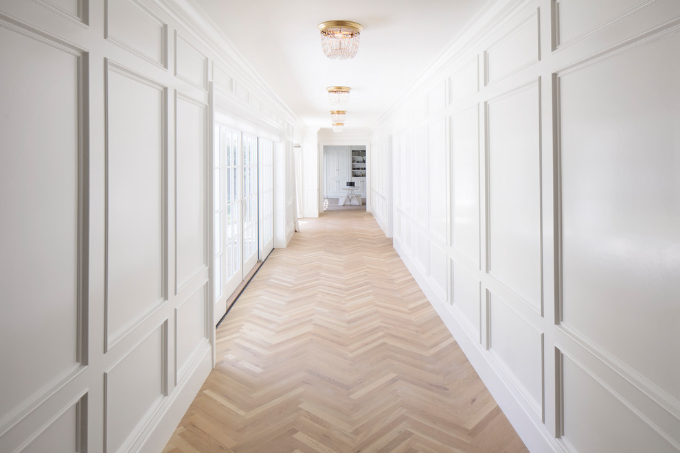 Foto de recibidores y pasillos clásicos grandes con paredes blancas, suelo de madera clara y suelo marrón